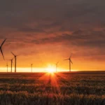 Wind turbines at sunset representing renewable energy, sustainability, and climate initiatives.